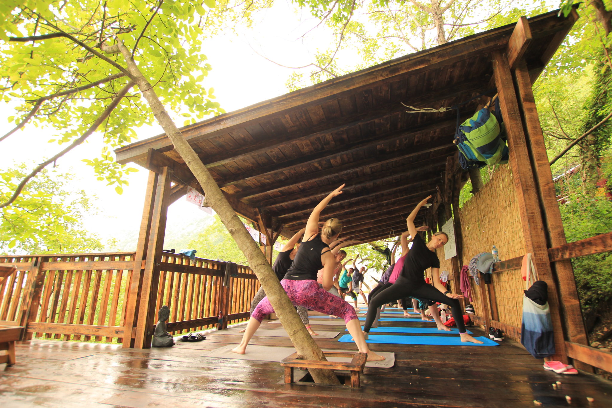 People on a yoga holiday in Montenegro participating in a yoga workshop outside on a wooden deck at Villa Miela near Lake Skadar