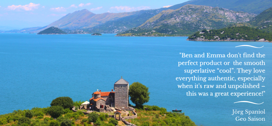 A remote island monastery at Lake Skadar with bright blue water, mountains and sunny sky in the background, plus white text with a quote from the German travel journalist Jorg Spaniol for Geo Saison recommending Undiscovered Montenegro
